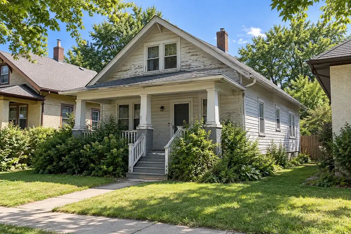 A house with peeling paint and worn roof shingles that needs repairs
